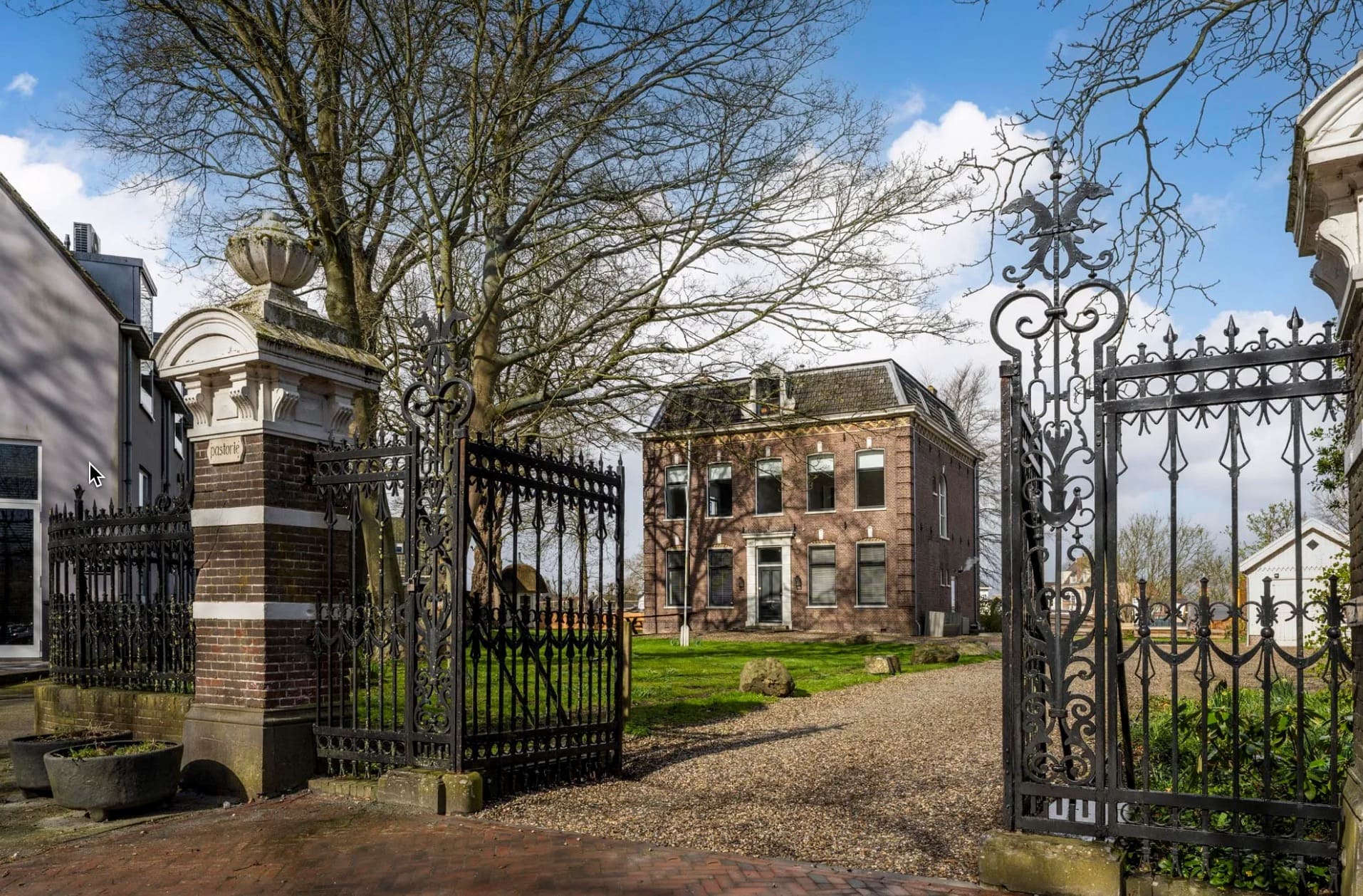 De open monumentale poort met zicht op de Pastorie